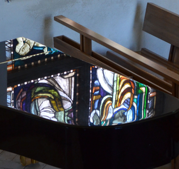 kirkon lasimaalauksen heijastuma flyygelin kanteen