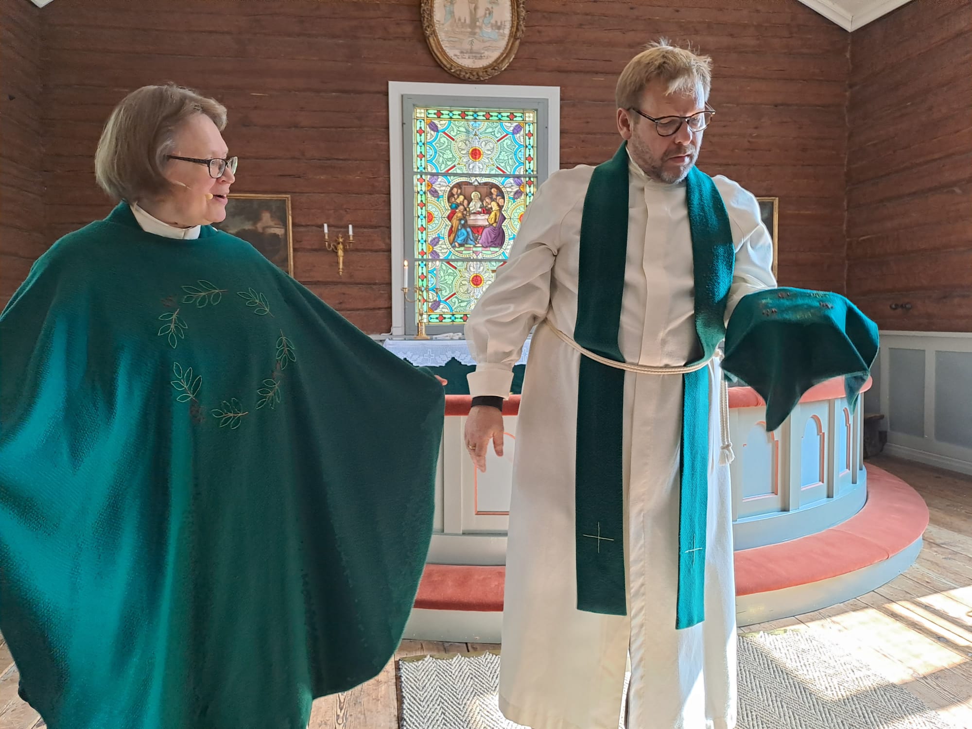 Kirkkoherrat esittelevät messun jälkeen Haapajärven kirkon uusia kirkkotekstiilejä.
