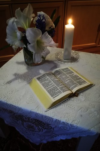 Kodin siunaaminen - olohuoneessa pöytä, jossa kukkia, kynttilä ja Raamattu.