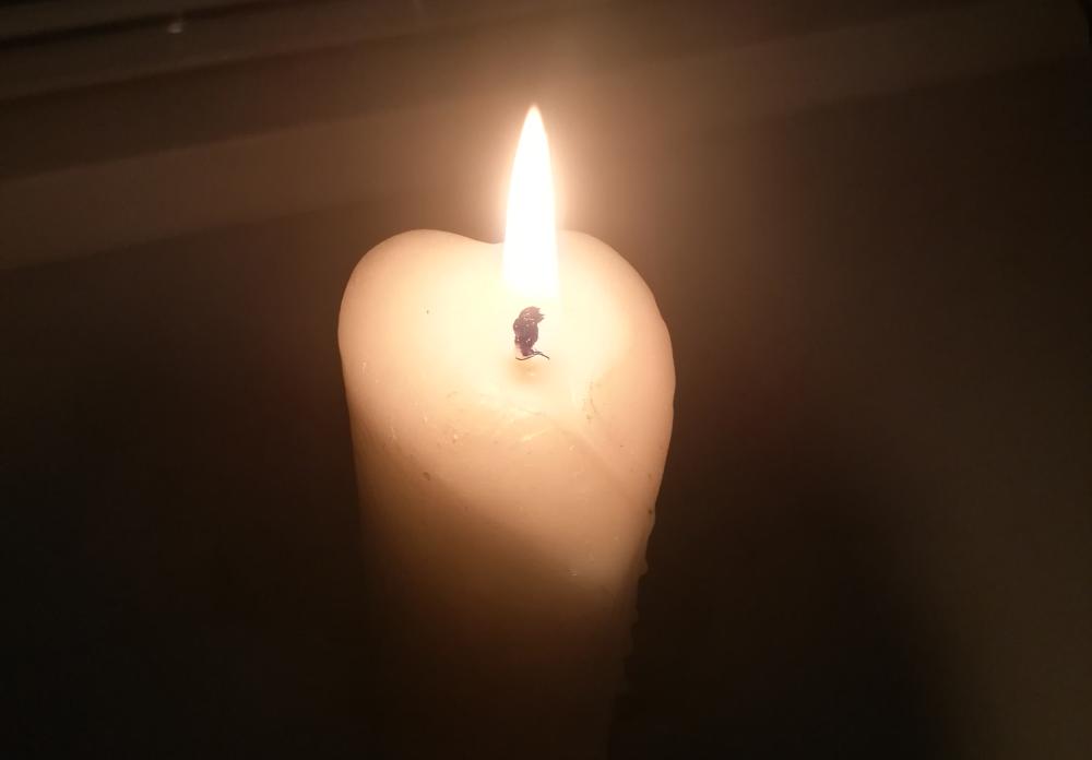 Sydämenmuotoinen kynttilä palaa pimeydessä.