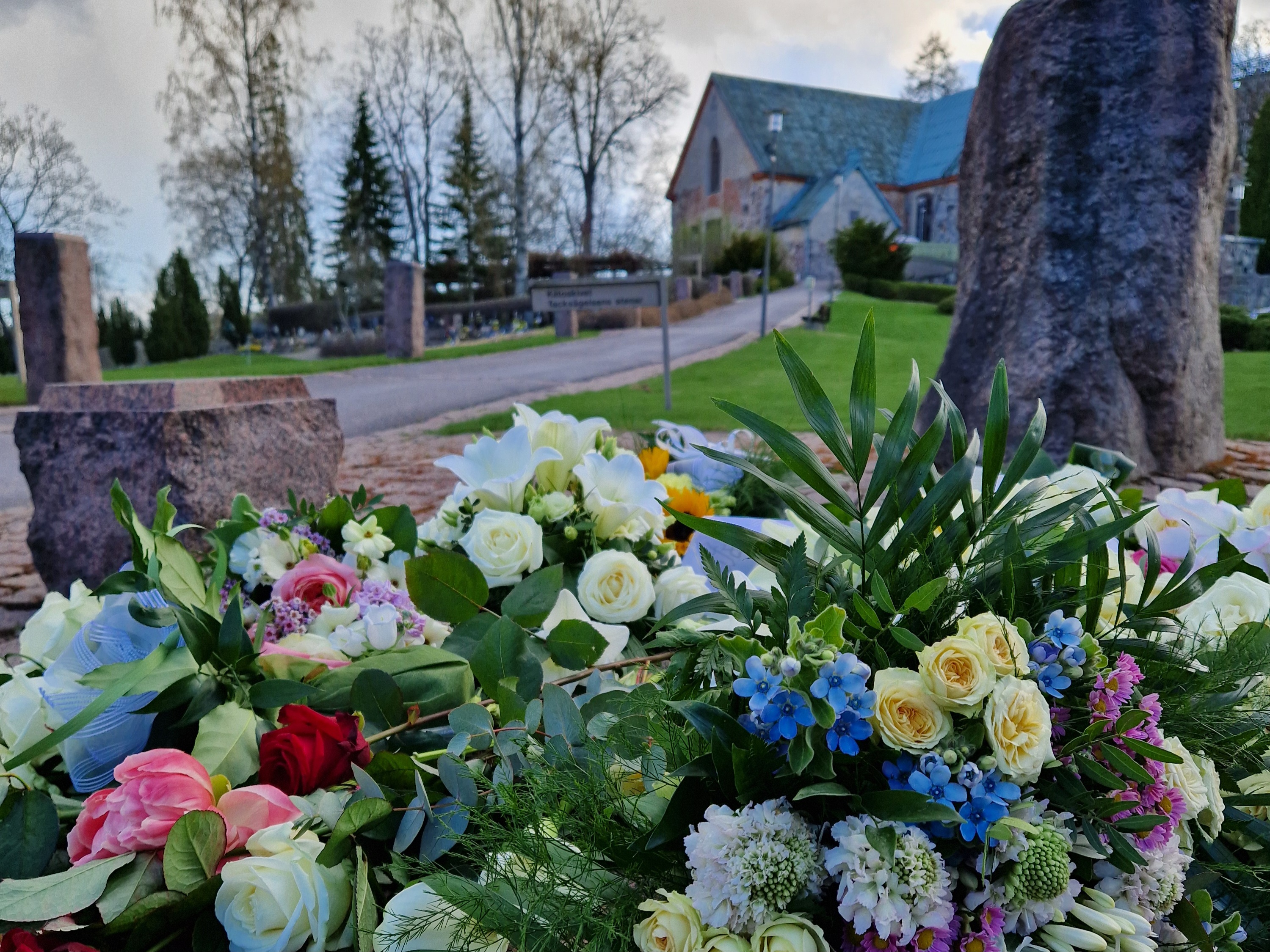 Kukkia Pyhän Mikaelin Uurnalehdon muistelukivillä.